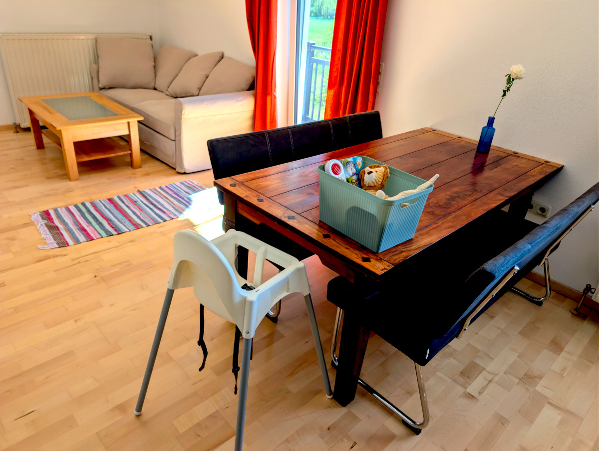 Massiver Esstisch aus Holz mit Hochstuhl und Spielzeugkiste